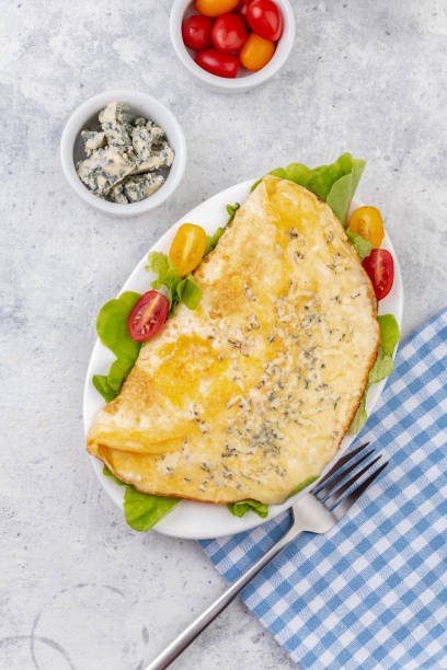 istock Fried eggs with cheese, cherry tomatoes and fresh lettuce. Omelet with filling for breakfast. Healthy or ketogenic or no carbohydrate food concept. 1294393824