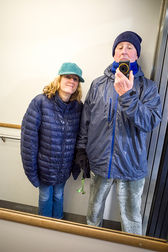 Stockholm, Sweden A couple take a selfie in the elevator mirror with soaked clothes from the rain after a walk.