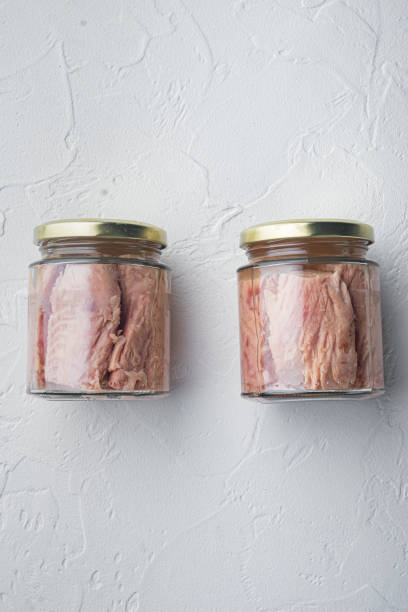 istock Tuna fillet in glass jar, on white background, flat lay  with copy space for text 1294395511