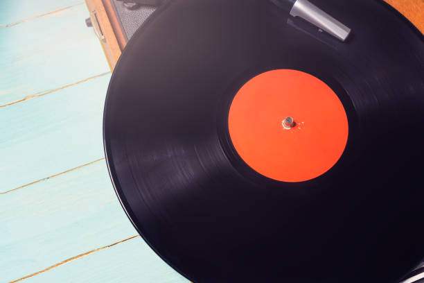 istock Vintage turntable with a vinyl record on rustic wooden table 1294397345