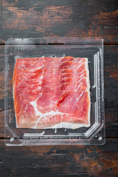 istock Prosciutto and herbs, on old wooden table, top view 1294397555