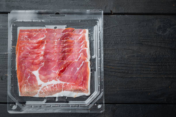 istock Prosciutto crudo, on black wooden background, top view  with copy space for text 1294398104