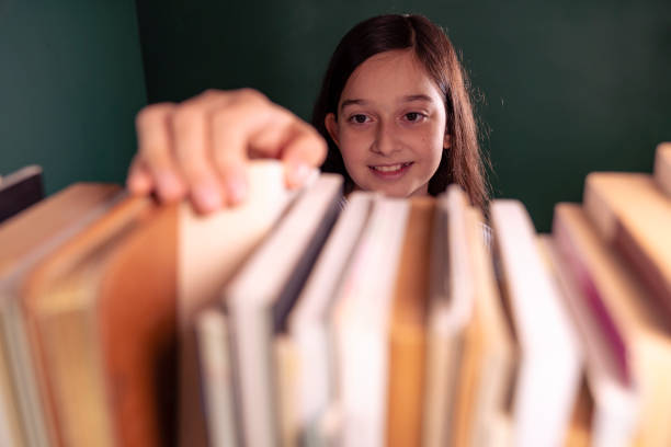 istock Little girl selects book 1294398122
