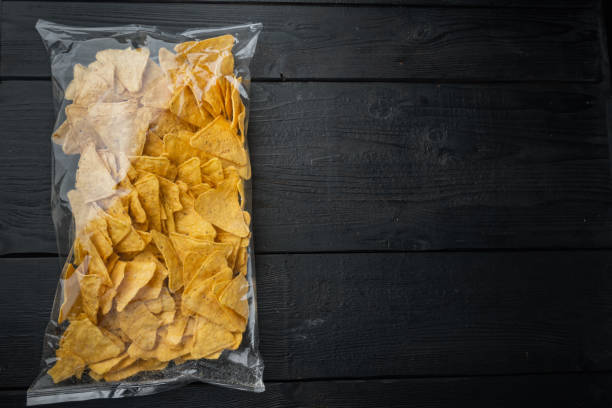 istock Corn traditional triangle nachos pack, on black wooden background, top view or flat lay with copy space for text 1294399120