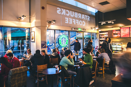 London, United Kingdom - December 2, 2011: Inside a large Starbucks cafe in a heart of London, near Tower Bridge. Always packed with locals and tourists wanting to get a cup of good coffee.