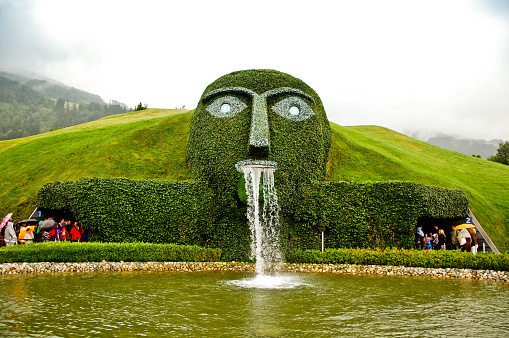 Wattens, Austria - July 14, 2011: Entrance to famous Swarovski Crystal Worlds which is the museum and headquarters of Swarovski crystals. This sculpture is called The Giant and is at the entrance gate. In the museum recognized artists, designers, and architects, such as Tord Boontje, Andy Warhol, Salvador Dalí, and Yayoi Kusama have interpreted crystal in their own ways.