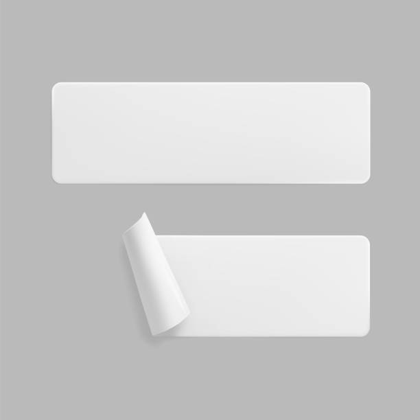 istock White glued rectangle stickers with curled corners mock up set. Blank white adhesive paper or plastic sticker label with wrinkled and creased effect. Template label tags close up. 3d realistic vector 1294401047