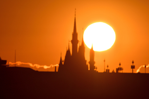 Tokyo, Japan-January 1, 2021: \nThe first sunrise of the year 2021 over Cinderella Castle of Tokyo Disneyland, which was taken on the morning of January 1, 2021, from across a part of Tokyo Bay at Kasai Rinkai (Seaside) Park, Edogawa Ward, Tokyo, by telephoto lens.