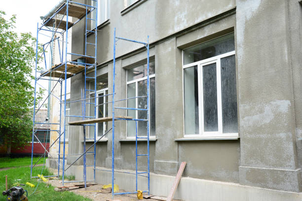 ristrutturazione della facciata di un edificio applicando finitura in stucco, intonacatura e finitura delle pareti esterne utilizzando impalcatura o messa in scena. - stucco building foto e immagini stock