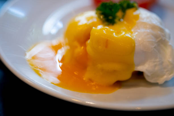 istock Close up of eggs benedict with liquid egg yolk running out. Selective focus 1294404843