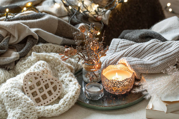 istock Cozy home composition with a burning candle and knitted elements. 1294404991