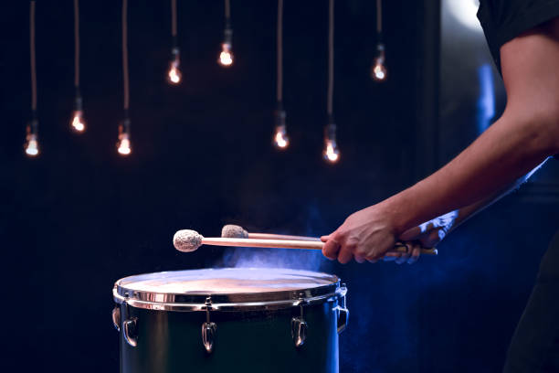 istock The drummer plays with mallets on floor tom in dark room. 1294406132