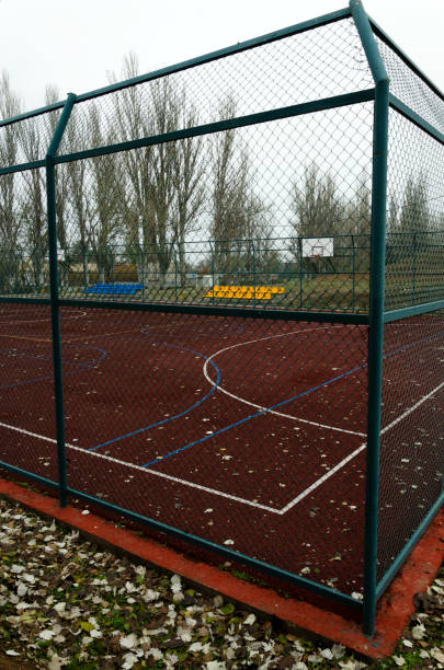 metallzaun, leerer sportplatz und plastiksitze im herbst. vertikales bild - athleticism multi colored red brown stock-fotos und bilder