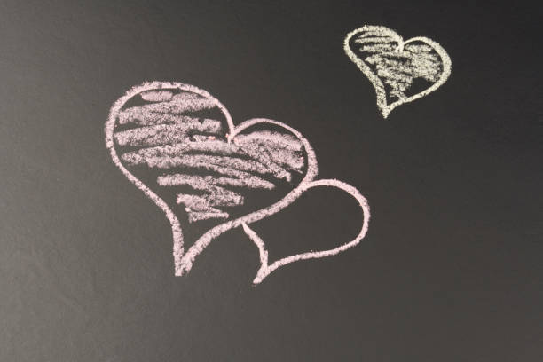 istock Hearts drawn in chalk on a black background, with copy space. 1294407189