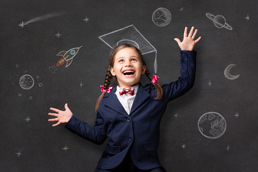 Portrait Of A Child Schoolgirl With Imagination At The Blackboard