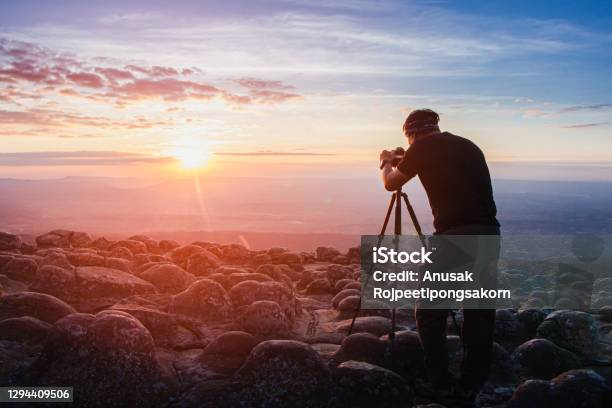 Man Photographer Holding A Camera To Shoot Nature Sunrise At Mountain Scenerytourists Take Pictures Of Sunset Nature With Camera On A Tripod With Copyspace Stock Photo - Download Image Now