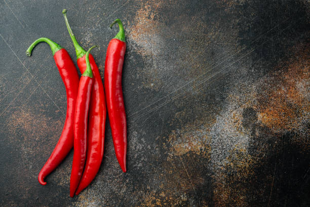 istock Whole red chili peppers, on old dark rustic background, top view or flat lay with copy space for text 1294409565