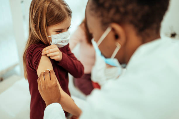 petite fille obtenant vaccinée - injecting flu virus cold and flu doctors office photos et images de collection