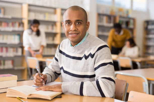 istock Cheerful adult hispanic student studying in university library 1294409952