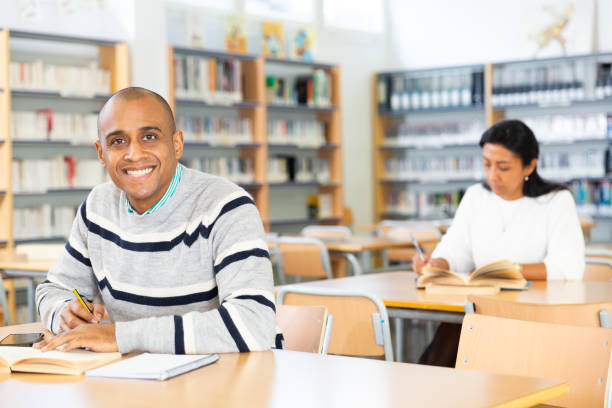 istock Young adult man studying in public library 1294411088