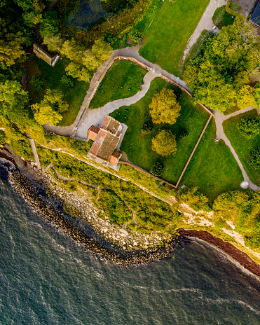 Drone view of the abandoned Hojerup Church at Stevns Klint in Denmark . The church dates back to 1250 but it was was abandoned in the early 20th century after the cliffs below started to fall into the sea, but it is maintained and it is now  a popular tourist spot. A new church was built a couple of hundred meters away.