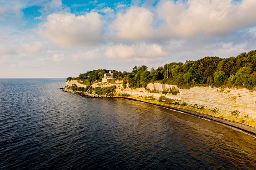 Drone view of the abandoned Hojerup Church at Stevns Klint in Denmark . The church dates back to 1250 but it was was abandoned in the early 20th century after the cliffs below started to fall into the sea, but it is maintained and it is now  a popular tourist attraction. A new church was built a couple of hundred meters away.