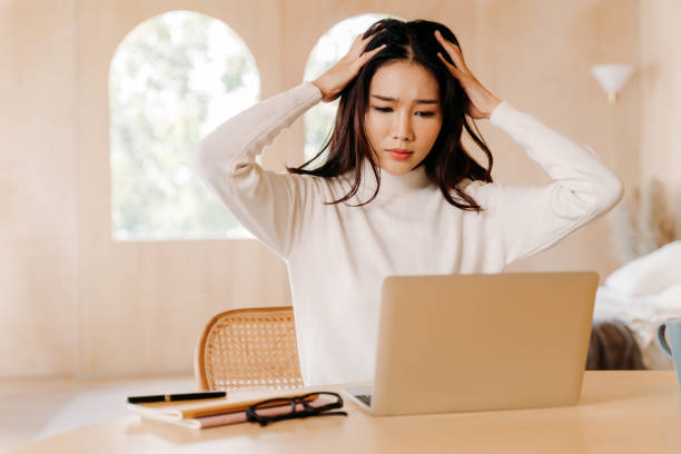 istock Tired Asian businesswoman having headache during work 1294411447