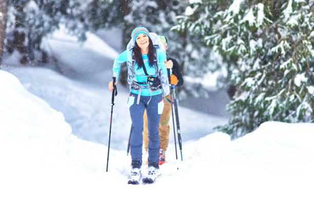 лыжные туры в лесу во время снегопада. счастливая девушка - ski skiing telemark skiing winter sport стоковые фото и изображения