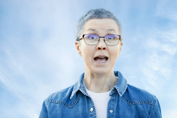 istock Woman with facial expression on the sky background 1294413843