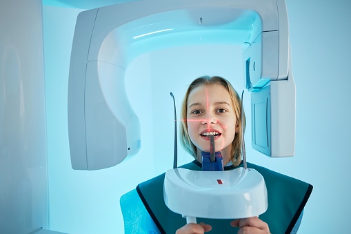 Modern dental surgery. Girl in clinic getting x-ray of teeth.