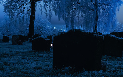 Tombstones in a frozen graveyard on a cold winters night.