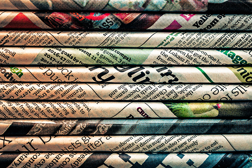 Macro abstract image depicting rolled sheets of newspaper.
