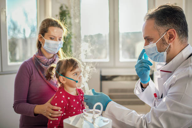 Medical doctor applying medicine inhalation treatment Medical doctor applying medicine inhalation treatment on a little baby girl by the mask of inhaler pediatric nebulizer mask stock pictures, royalty-free photos & images