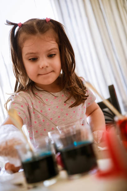 istock Focused little girl dying eggs for Easter 1294420956