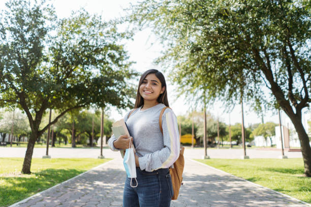 istock Latin student smiling and holding protective face mask 1294421838