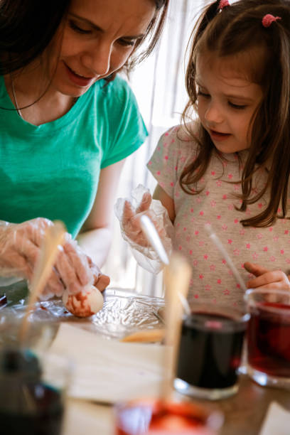 istock Mother and her little daughter bonding while dying eggs for Easter 1294421975