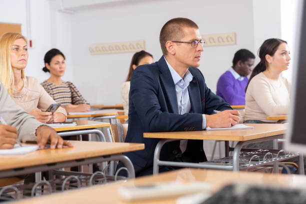 istock Attentive students at their desks in university auditorium 1294422682