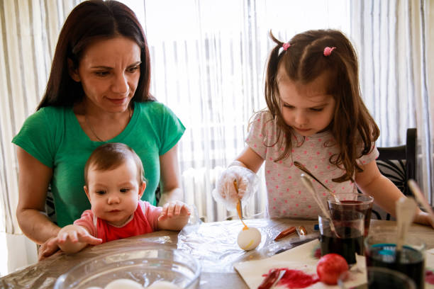 istock Little girl decorating an Easter egg with yellow dye 1294424921