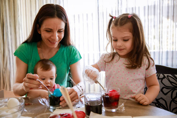 istock Woman enjoying while dying Easter eggs with her two little daughters 1294424984