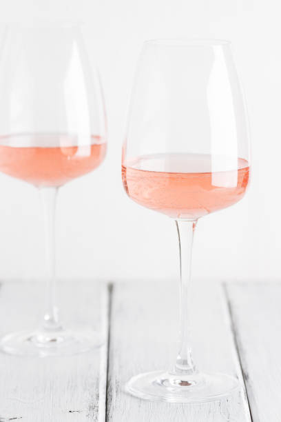 Rose wine in glasses on a white old wooden table. Selective focus. Wine tasting concept.