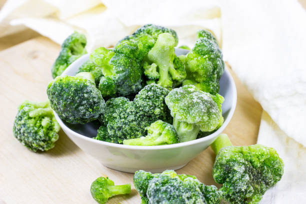 istock Fresh green frozen broccoli in small white bowl on light background 1294427486