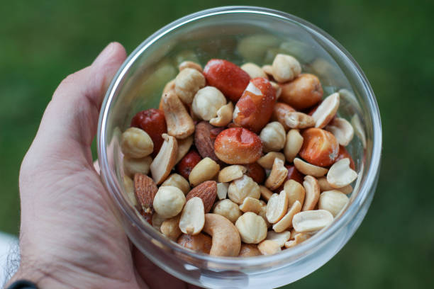 istock Mixed nuts in glass bowl in hand. 1294429325
