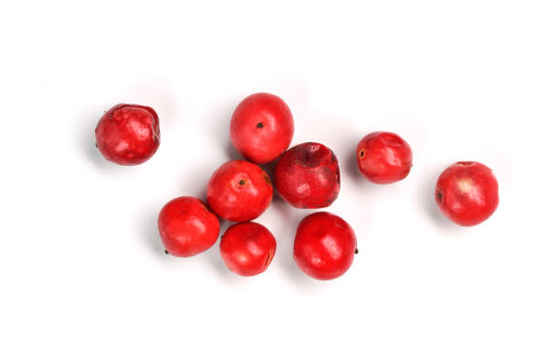 ボード上の赤またはピンクのペッパーコーン、白い背景で隔離されたクローズアップ写真 - pink peppercorn ストックフォトと画像