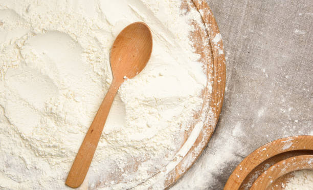 istock white wheat flour in a wooden spoon, top view 1294431679