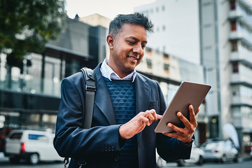 Shot of a businessman using a digital tablet against a city background