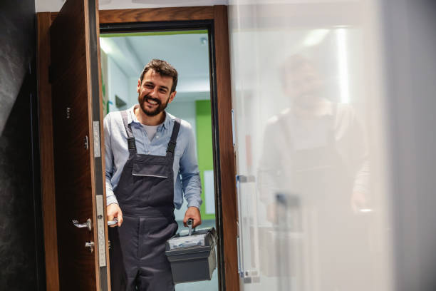 istock Repairman holding his box with tools and entering house. 1294438535