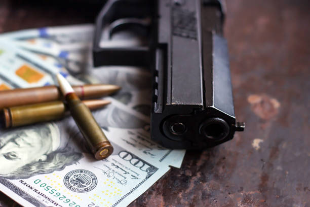schwarze pistole und kugeln auf us-dollar hintergrund. militärindustrie, krieg, globaler waffenhandel, waffenverkauf, auftragstötung und verbrechenskonzept - currency crime gun conflict stock-fotos und bilder