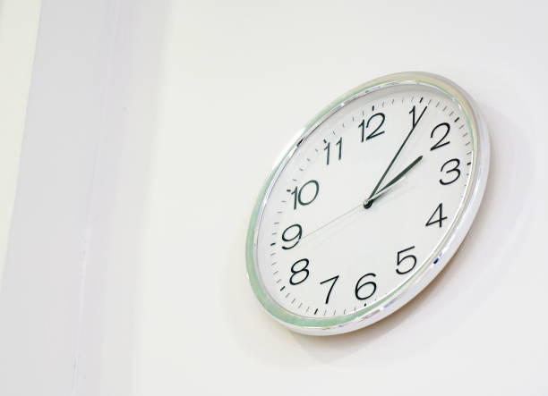 istock Round metal clock on white wall 1294438753
