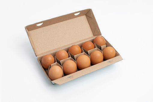 Ten eggs in brown carton on white