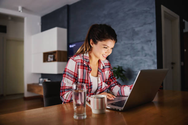 istock Smiling woman sitting at home during lockdown and getting her job done. 1294439618